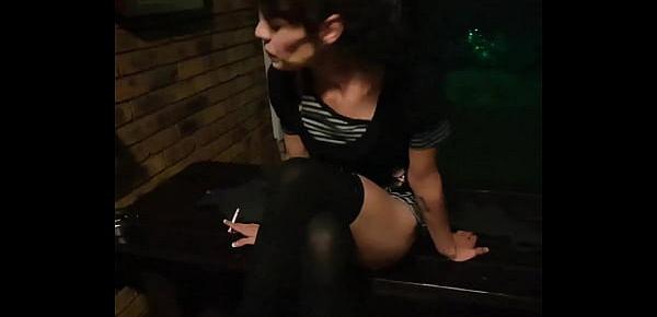  Petite brunette posing in different positions while smoking a cigarette outside in the garden